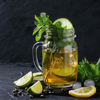bevereage in a glass container with lemon slices and mint