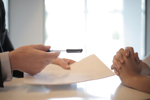 Person handing a form to another person