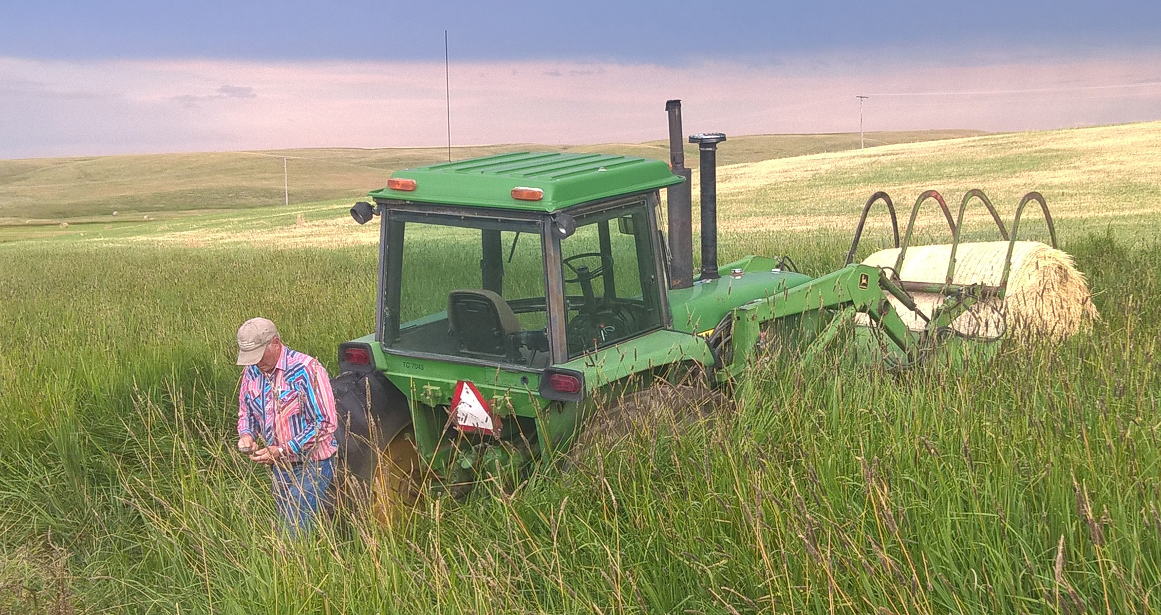 Farmer in Field with Hay Baler