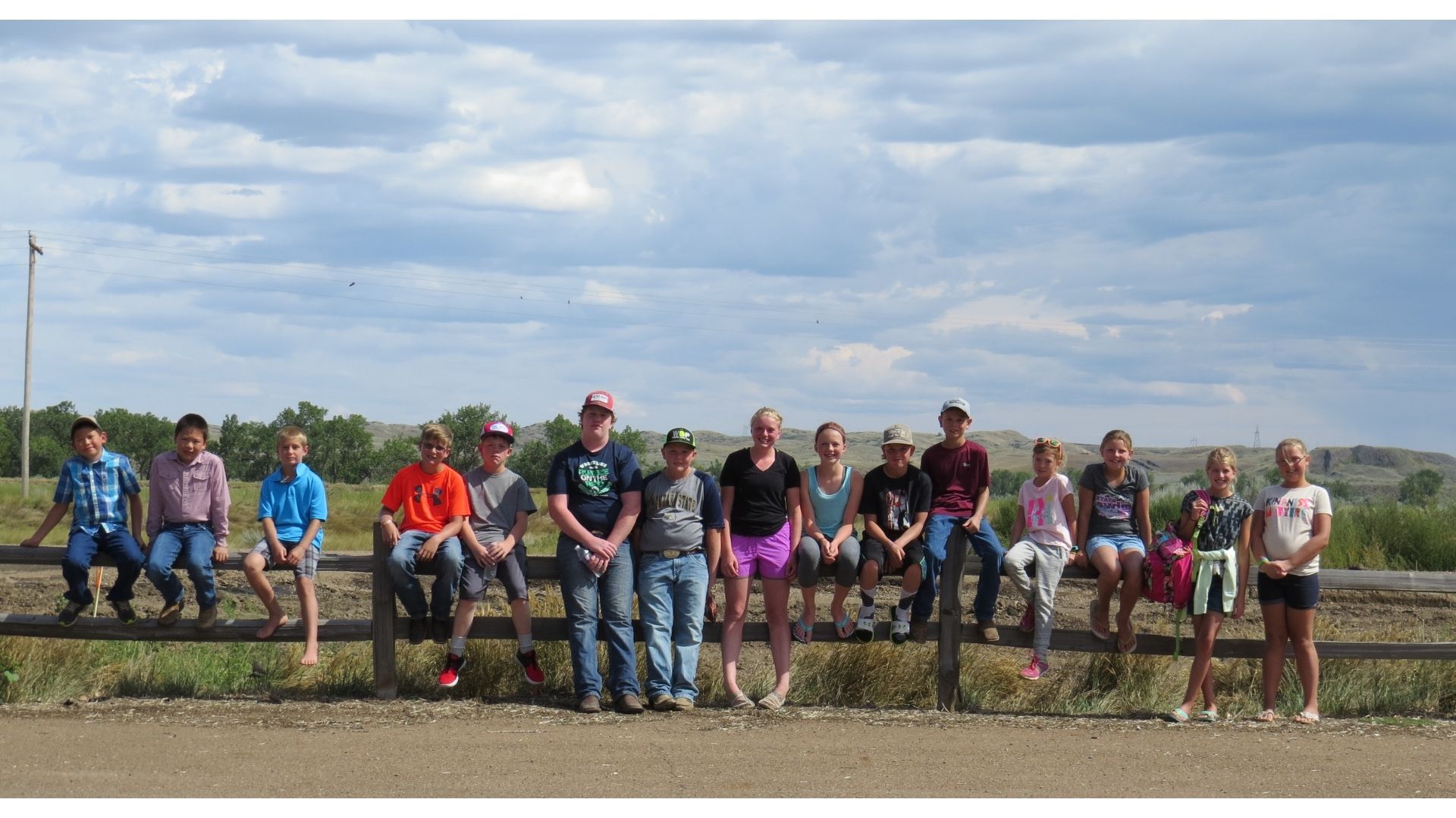 Club members sit together on a fence.