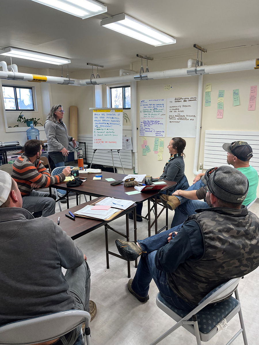 Volunteer group sits at a classroom table while drafting their mission statement for the housing co-op