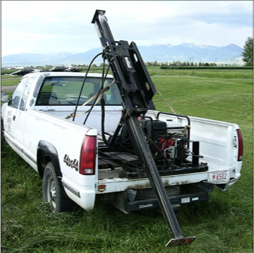 a large hydraulic probe mounted in the bed of a truck.