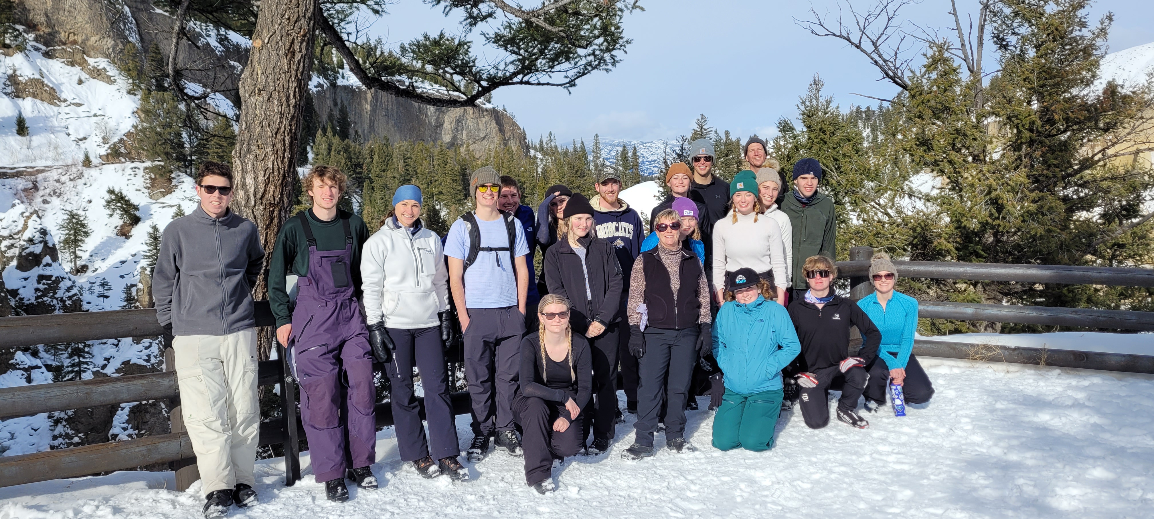 people standing in a snowy landscape smile at the camera