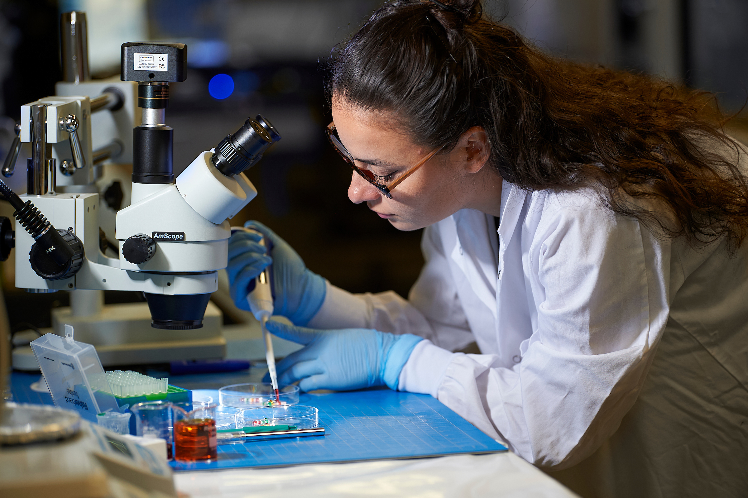 woman in lab coat with tools